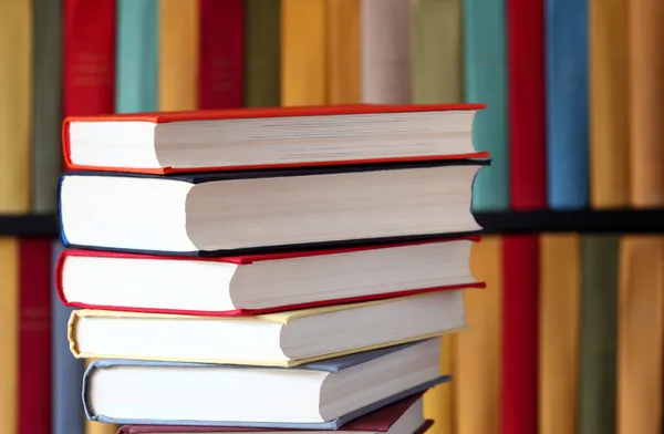 Gestapelde boeken en boekenplanken — Stockfoto