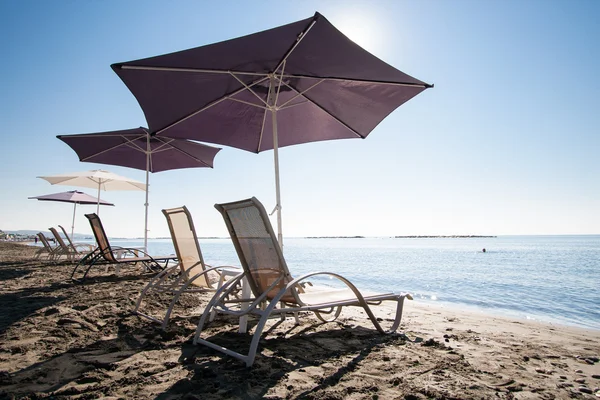 Cadeiras de praia e guarda-chuvas — Fotografia de Stock