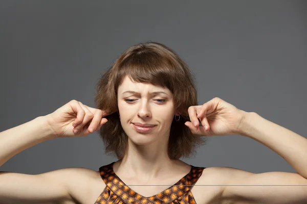 Foto de mujer joven con los dedos en las orejas — Foto de Stock