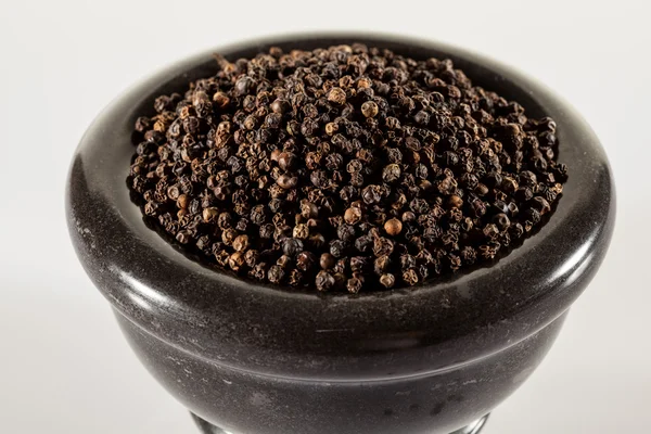 Black peppers in a clay pot — Stock Photo, Image