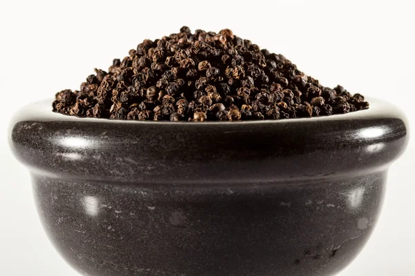 Black paprika's in een klei pot — Stockfoto