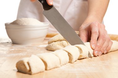 Housewife cutting sweet rolls on the wooden board
