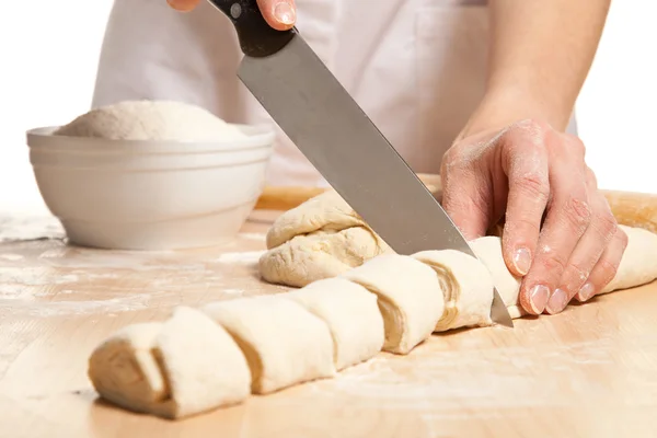 Housewife cutting sweet rolls on the wooden board — Stock Photo, Image