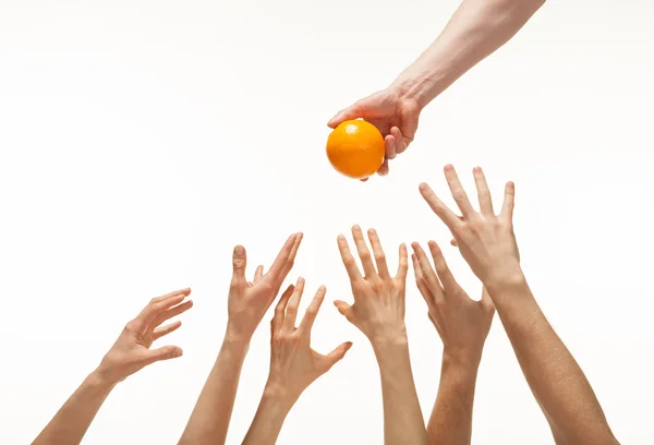 Many hands want to get orange — Stock Photo, Image