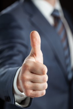 İşadamı başparmaklarını gösteriyor