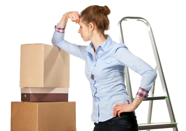 Sad young woman near a pile of boxes — Stock Photo, Image