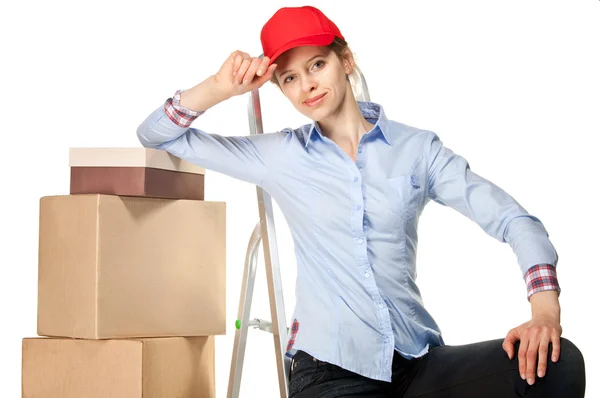 Smiling young woman near a pile of boxes — Stock Photo, Image