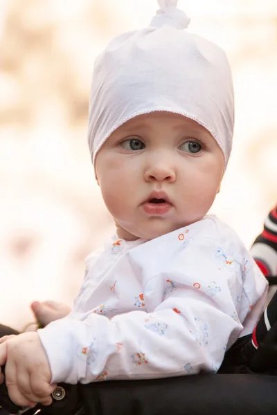 Baby girl sitting in a perambulator — Stock Photo, Image