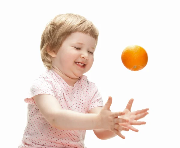 Criança feliz brincando com laranja — Fotografia de Stock