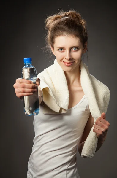 Jonge vrouw met fles water na fitness oefening — Stockfoto