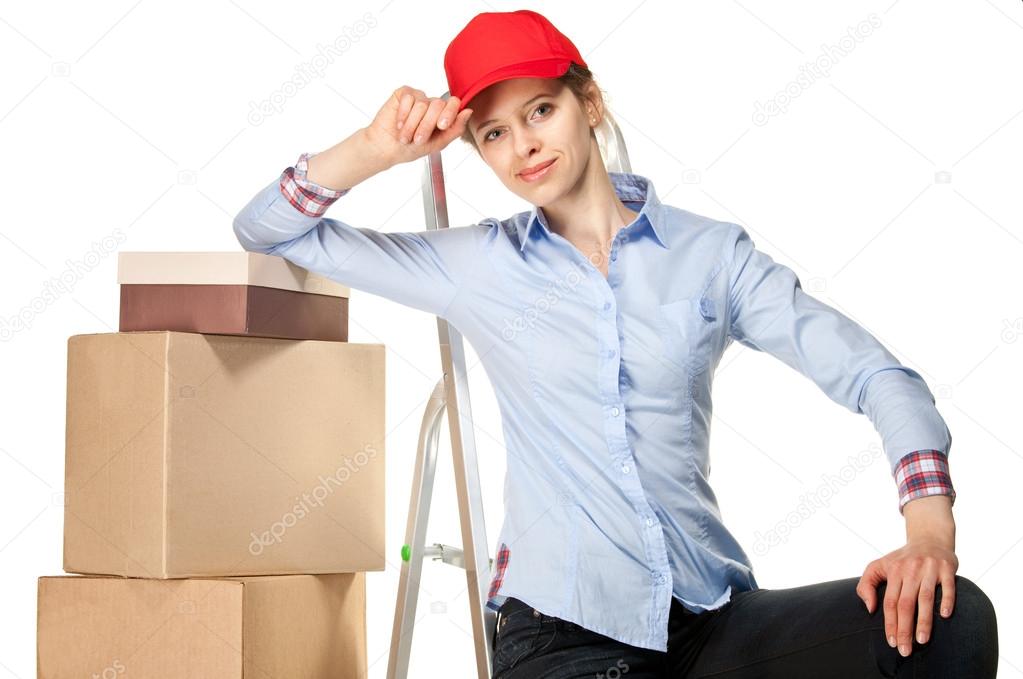 Smiling young woman near a pile of boxes