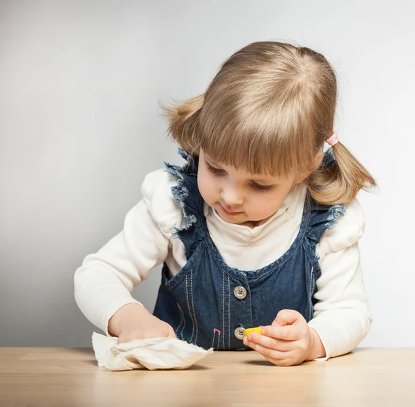 Little girl dusts at the table — Stock Photo, Image