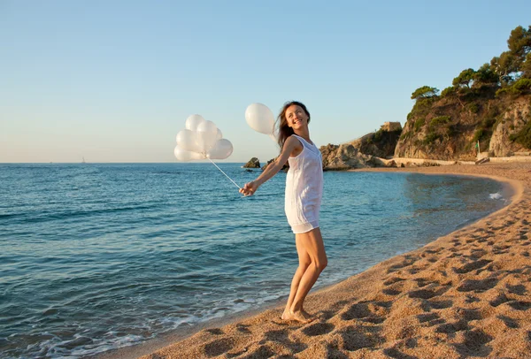 Sunny Beach beyaz balonlarla esmer kız gülümseyerek mutlu — Stok fotoğraf