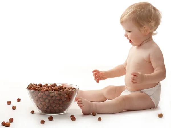 Het meisje van de baby met hazelnoten — Stockfoto