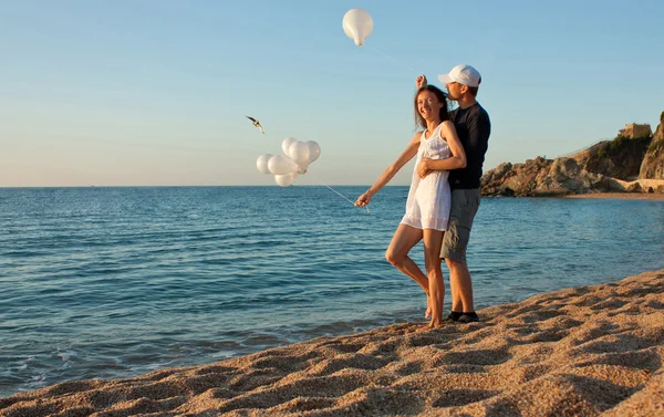 Счастливая молодая пара веселится на солнечном пляже — стоковое фото