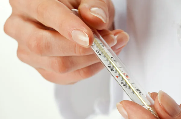 Händer som håller termometer — Stockfoto