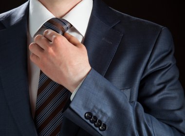 Businessman adjusting his tie clipart