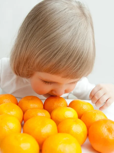 The baby girl with tangerines. — Stock Photo, Image