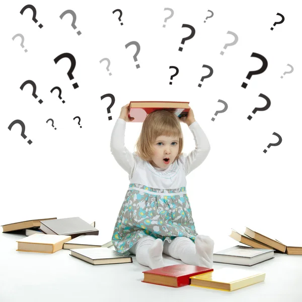 Little child surrounded by books and question marks — Stock Photo, Image