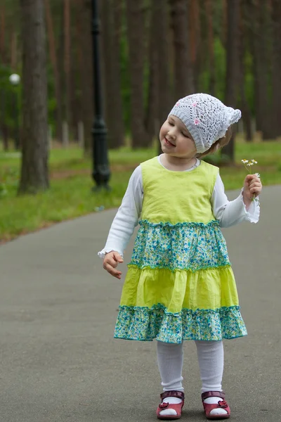 Glada leende liten flicka vandrar i en sommar park — Stockfoto