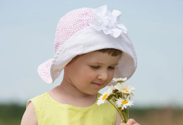 Beautiful little girl holding camomiles — Stock Photo, Image