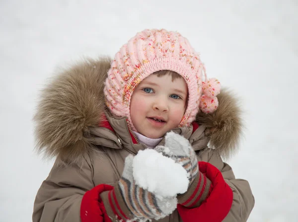 小さな女の子が雪玉で遊んで — ストック写真