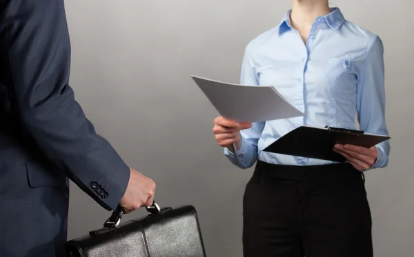 Femme d'affaires tend la main aux documents à un homme d'affaires avec briefc — Photo