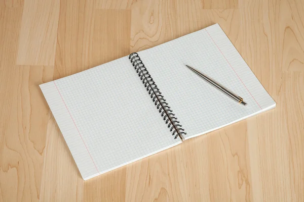 Kvadrerat pappers kopia bok och en penna — Stockfoto