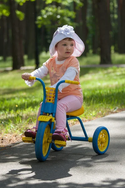 Bella bambina cavalca triciclo — Foto Stock