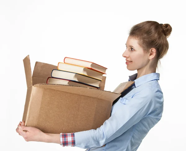 Mulher sorridente carregando uma caixa de papelão com livros — Fotografia de Stock