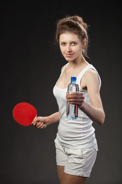 Young woman holding a bottle of water and tennis racquet — Stock Photo, Image