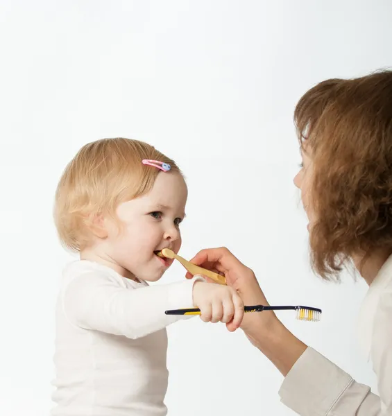 Giovane madre aiutare il suo piccolo dauther pulizia i denti — Foto Stock