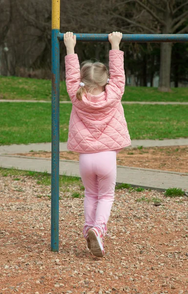 Aktiva lilla barnet klättra på en tvärbalken — Stockfoto