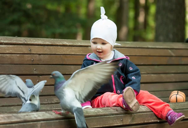 Söt liten flicka och duvor — Stockfoto