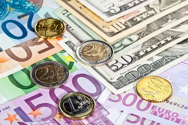 Muchos billetes y monedas en euros y dólares — Foto de Stock