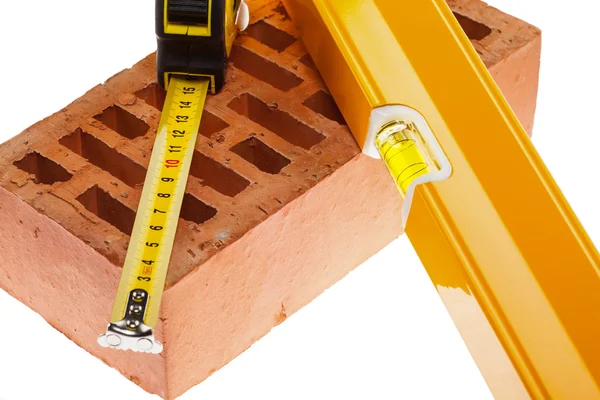 Level tape line and a brick — Stock Photo, Image