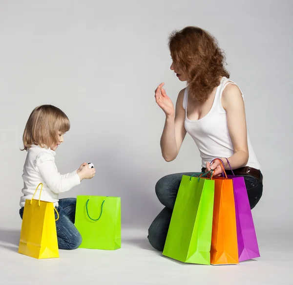 Petite fille avec sa mère examinant les achats — Photo