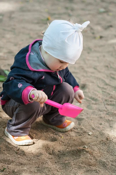 Little girl playing in a sandpit — Stock Photo, Image