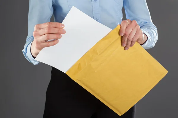 Businesswoman taking letter out of envelope — Stock Photo, Image