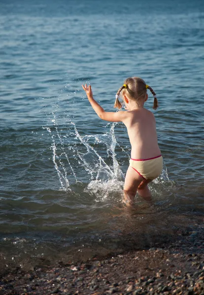 Klein meisje spelen aan de kust — Stockfoto