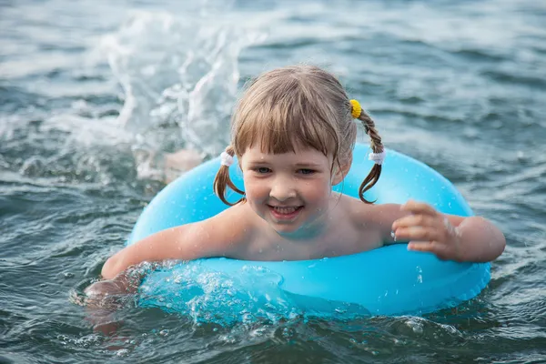 Söt liten flicka simma med uppblåsbara cirkel — Stockfoto