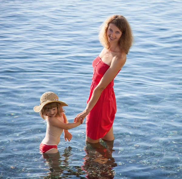 Mère et fille heureuses marchant près du bord de mer — Photo