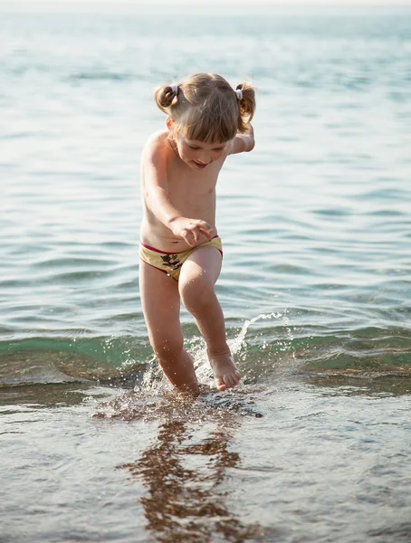 Liten flicka som leker på stranden — Stockfoto
