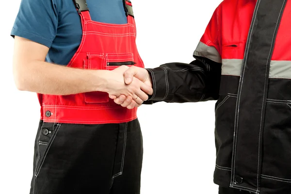Промышленные рабочие в форме пожимают руки — стоковое фото