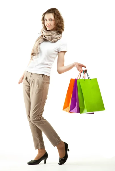 Happy beautiful young woman holding multicolored paper bags — Stock Photo, Image