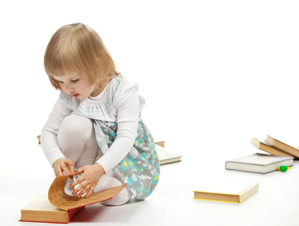 Das kleine Mädchen beim Betrachten des Buches — Stockfoto