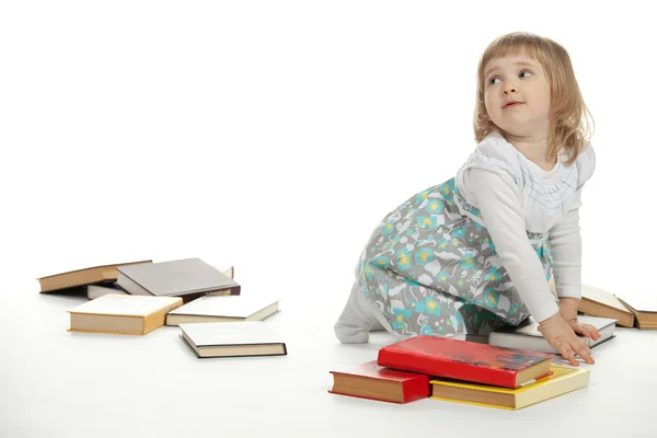 La petite fille assise parmi les livres — Photo