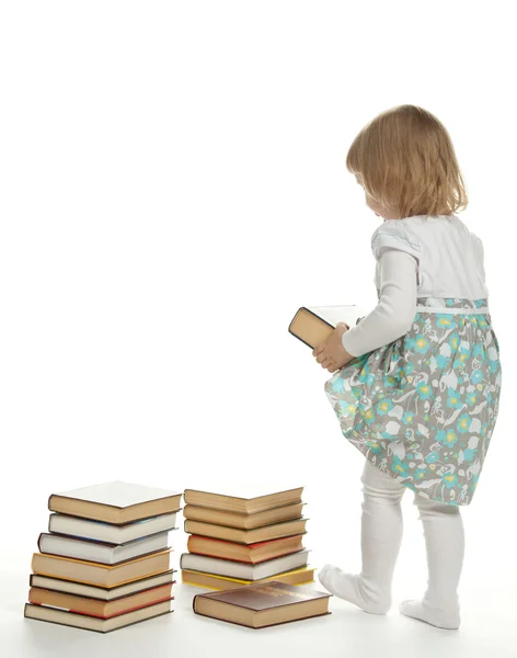 A little girl raising a big book Stock Picture