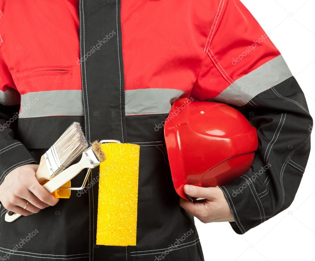 Construction worker in uniform holding hardhat, paint roller and