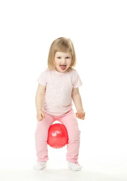 Glada skratt lilla flickan gör övningar med en boll — Stockfoto